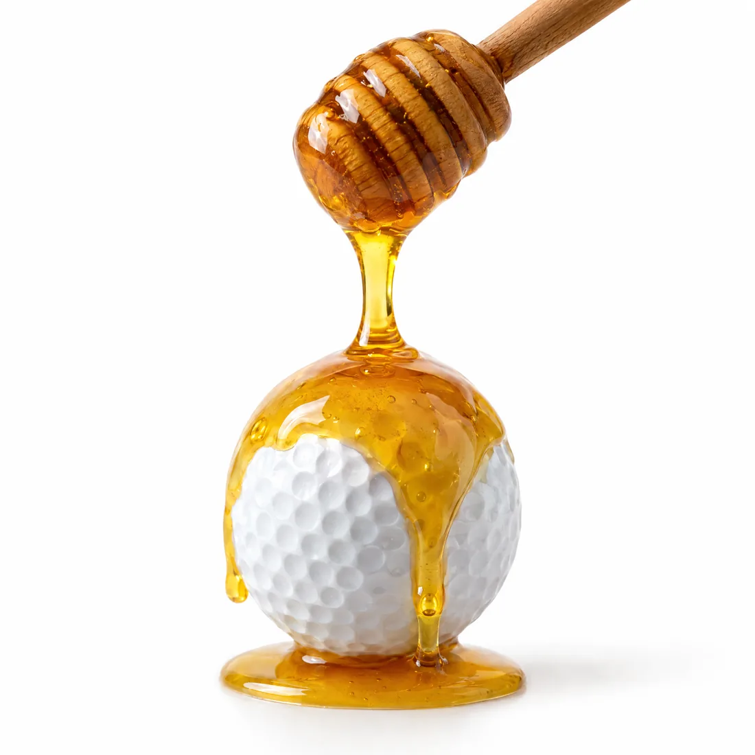 Honey drizzling beside a golf ball.
