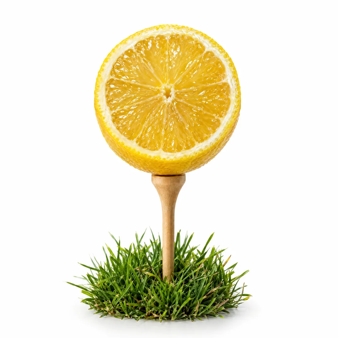 A cut lemon resting beside a golf tee.